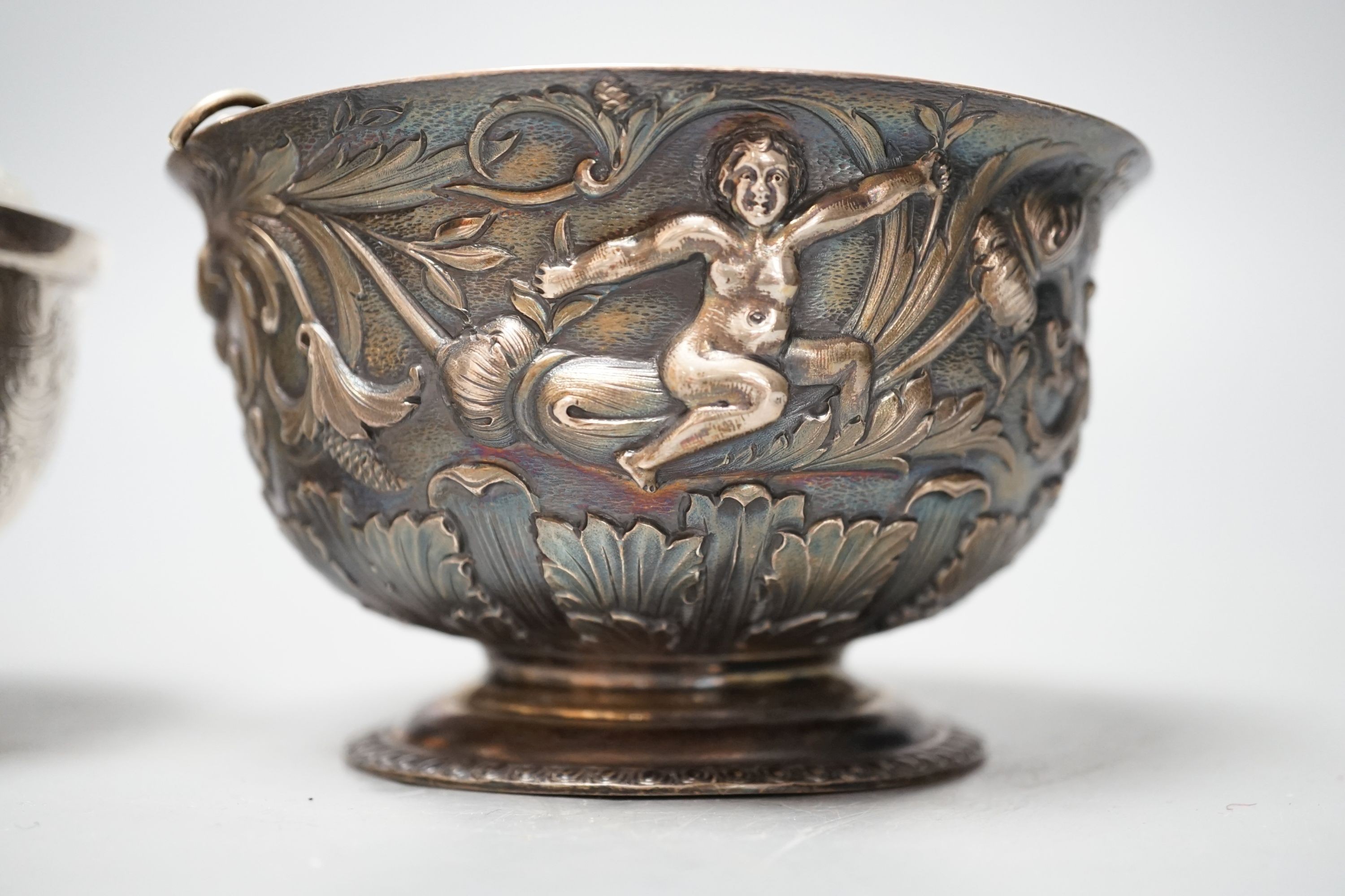 An Edwardian silver bowl, embossed with putto amid scrolls, London, 1902, diameter 13.1cm and a white metal bowl and cover, gross 20.5oz.